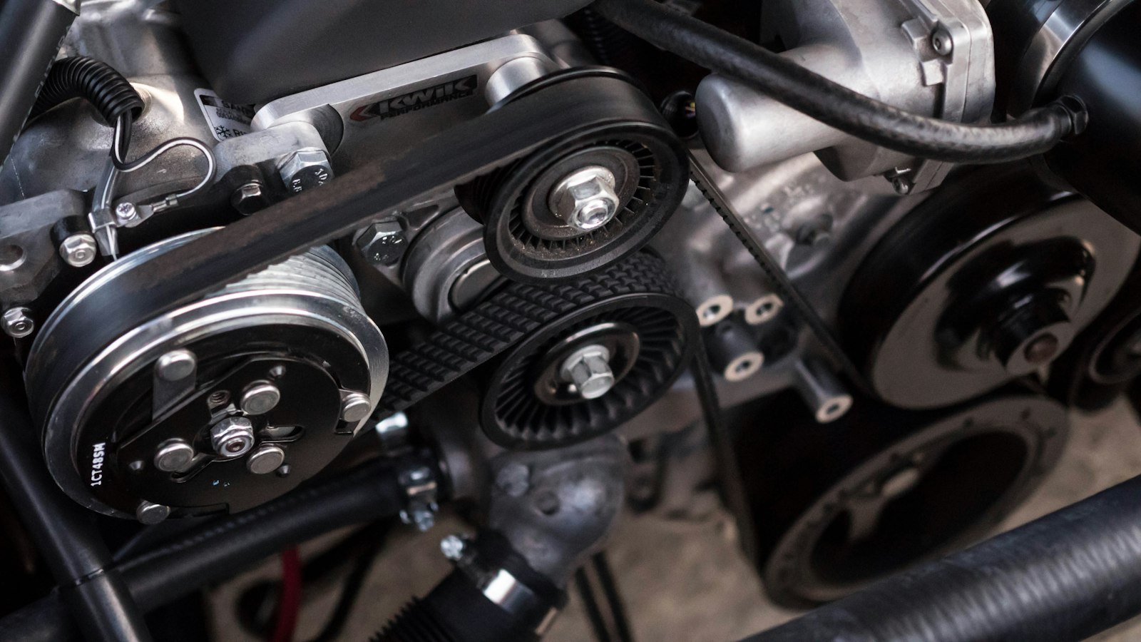 Close view of an engine belt and pulleys